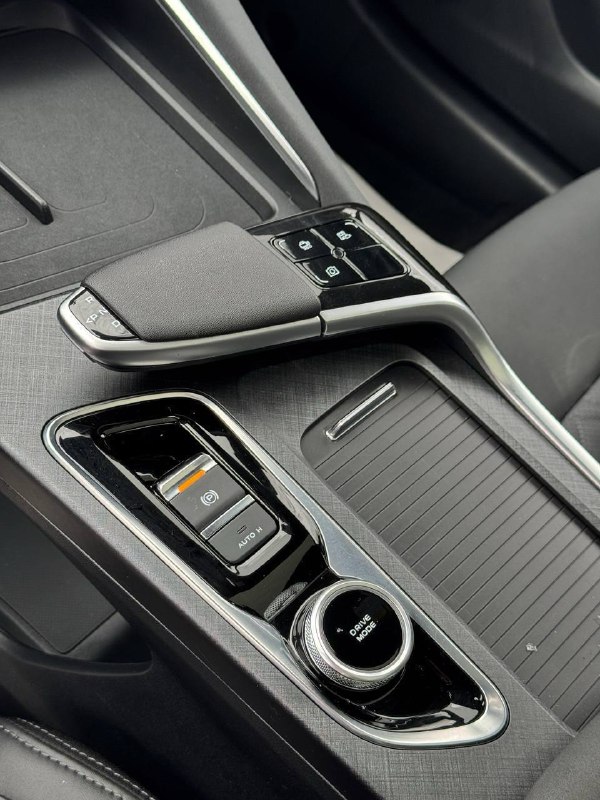 Деталь центрального тоннеля Changan Uni‑T: селектор коробки, роторный регулятор режимов и подстаканник в интерьере автомобиля.