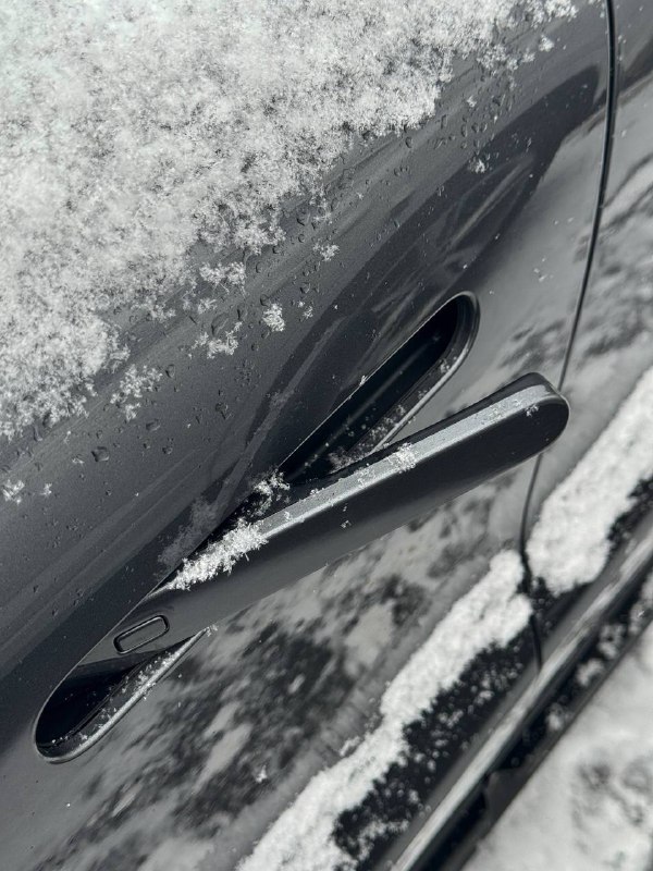 Деталь дверной ручки и боковой панели Changan Uni‑T, покрытые снегом — крупный план, демонстрирующий качество окраски и фурнитуры.