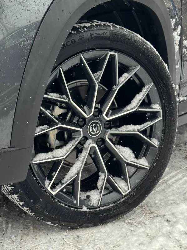 Литой диск и шина Changan Uni‑T на заснеженной поверхности — дизайн легкосплавного диска и профиль зимней шины.