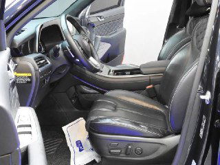 Водительское сиденье Hyundai Palisade крупным планом: кожа, регулировки сиденья и общий вид передней секции салона и дверной обивки.