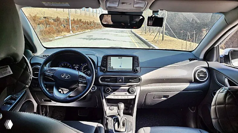 Фото салона Hyundai Kona — вид на панель, руль и центральную консоль; демонстрация состояния интерьера и мультимедиа.