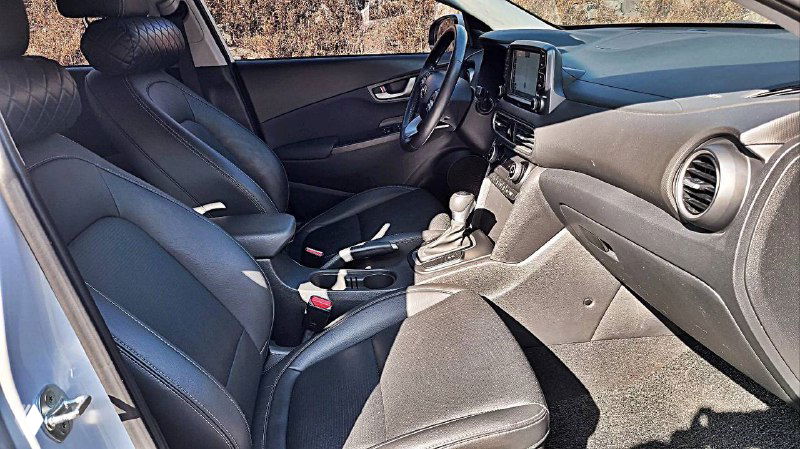 Внутренний вид передних сидений Hyundai Kona, чёрная обивка и элементы отделки, состояние кресел и пространства водителя.