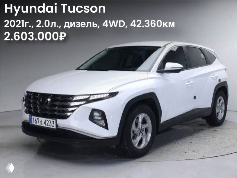 Белый Hyundai Tucson 2021 года — вид спереди и сбоку на нейтральном фоне, заметны решётка радиатора и общий дизайн кузова.