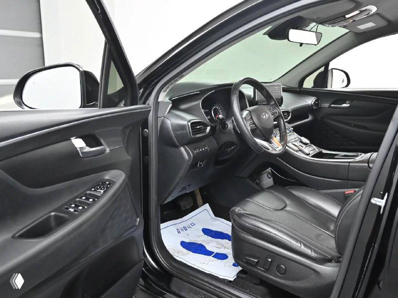 Вид водительской зоны Hyundai Santa Fe со стороны двери, показаны элементы управления и обивка сиденья для оценки состояния перед покупкой из Кореи.