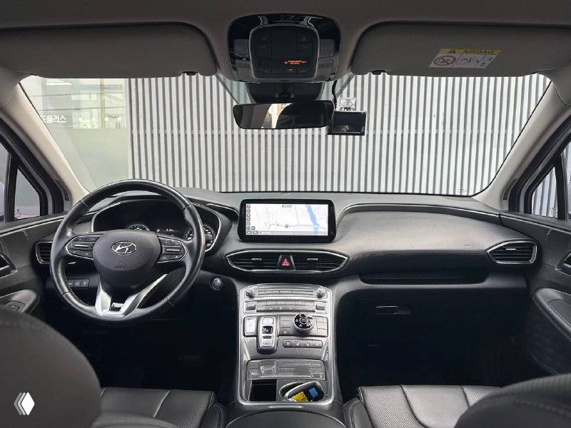 Интерьер гибридного Hyundai Santa Fe, вид на центральную консоль и панель; фото полезно для оценки комплектации и состояния салона перед импортом.