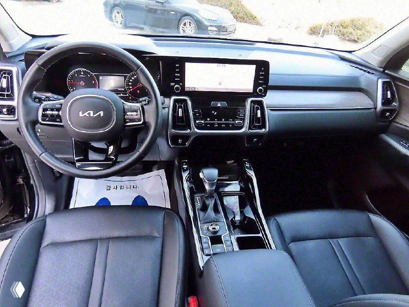 Салон KIA Sorento 2021: вид на панель приборов, руль и центральную консоль с мультимедиа и отделкой кожи и пластика.