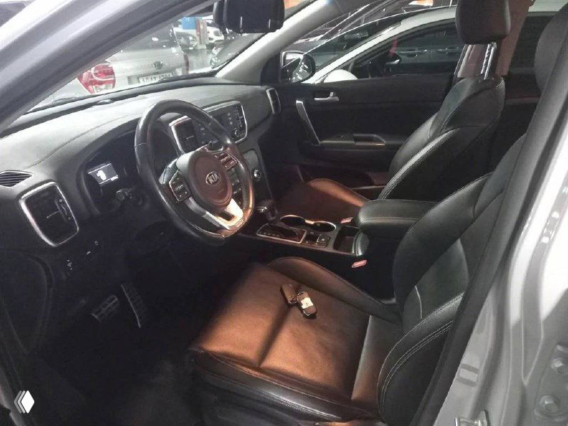 Вид салона KIA Sportage 2021 с акцентом на передние сиденья и центральный туннель; показана отделка и эргономика посадки.