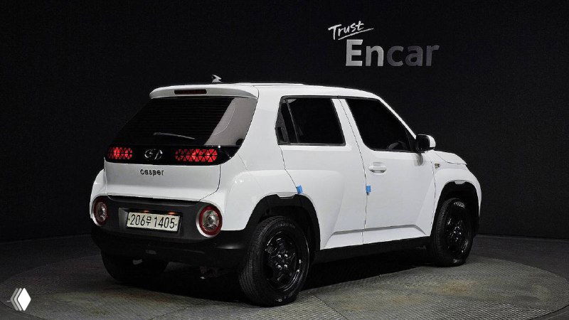 Белый Hyundai Casper, вид сзади-слева в студийных условиях, видна задняя оптика, багажная дверь и общая геометрия кузова автомобиля.