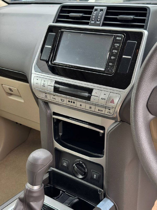 Центральная консоль Toyota Prado с экраном мультимедиа, элементами климат-контроля и отделением для мелких предметов крупным планом