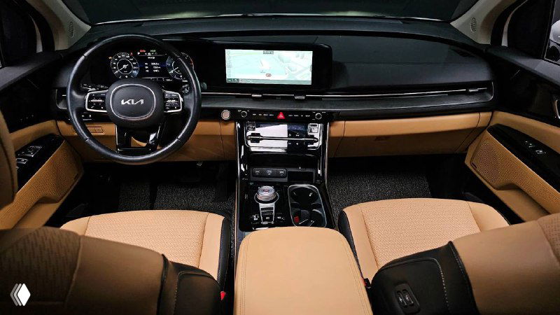 Салон KIA Carnival Signature 2021 — передняя панель, мультимедиа-экран и бежевые кожаные сиденья, показана приборная панель и центральная консоль.