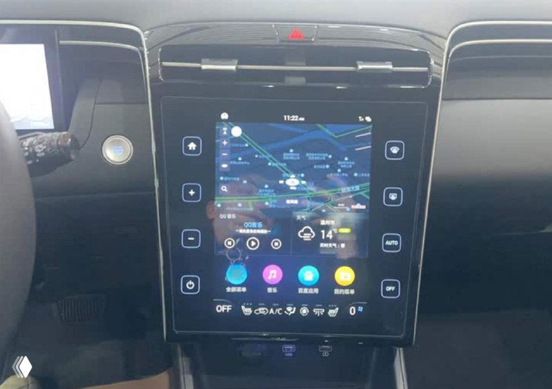 Интерьер Tucson: крупный вертикальный сенсорный экран мультимедиа на центральной консоли, элементы управления и отображение интерфейса в дилерской сборке.