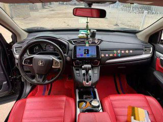 Интерьер чёрной Honda CR‑V с красной кожаной отделкой: общая панорама салона, передние сиденья и центральная консоль с экраном.