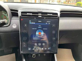 Крупный план вертикального сенсорного дисплея мультимедиа в Hyundai Tucson 2022: интерфейс и сенсорные кнопки на видимом экране.