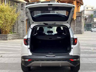 Открытый багажник белого Hyundai Tucson 2022 с пустым грузовым отделением; видна внутренняя отделка и возможный объём для поклажи.