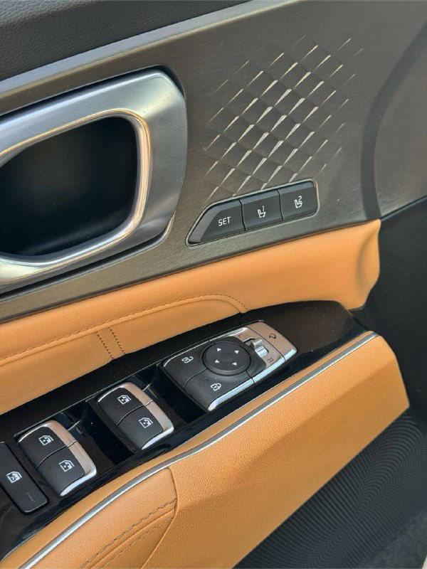 Блок кнопок на дверной панели: управление стеклоподъёмниками, память сидений и кнопки блокировки; коричневая кожа и хромированная отделка.