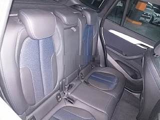 Задний ряд сидений BMW X1 с комбинированной отделкой; фото заднего салона показывает состояние кресел и пространства для пассажиров.