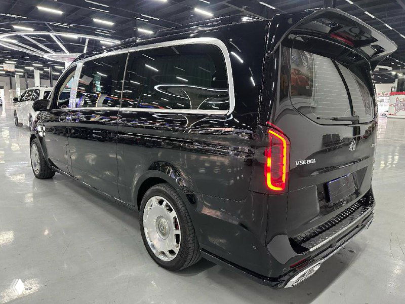 Задняя часть и боковой профиль чёрного Mercedes Vito на стоянке в шоуруме, видна форма фонарей и объём багажника.