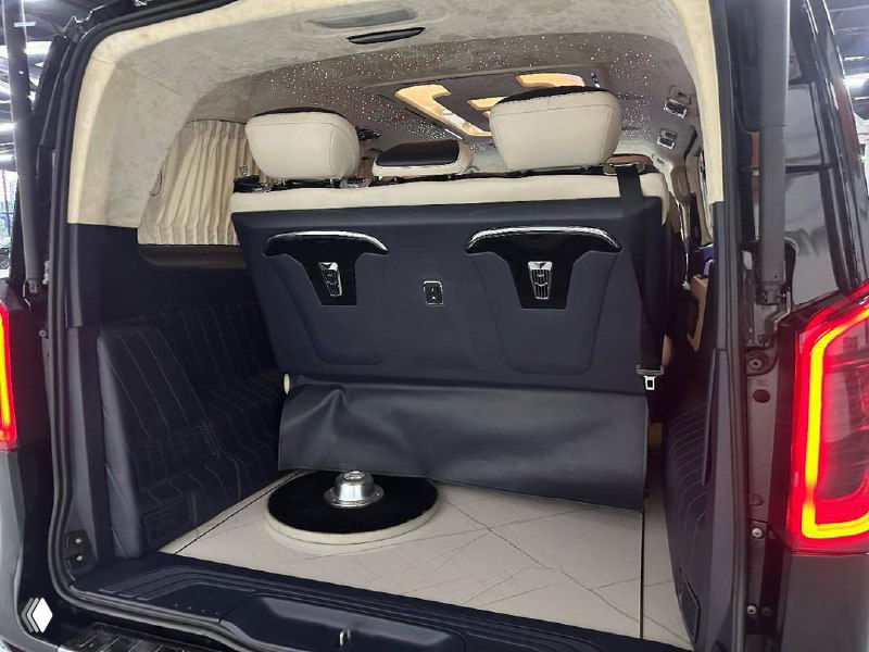 Багажное отделение Mercedes Vito с поднятыми частями кресел и ровным полом, видны крепления и объём для перевозки грузов.