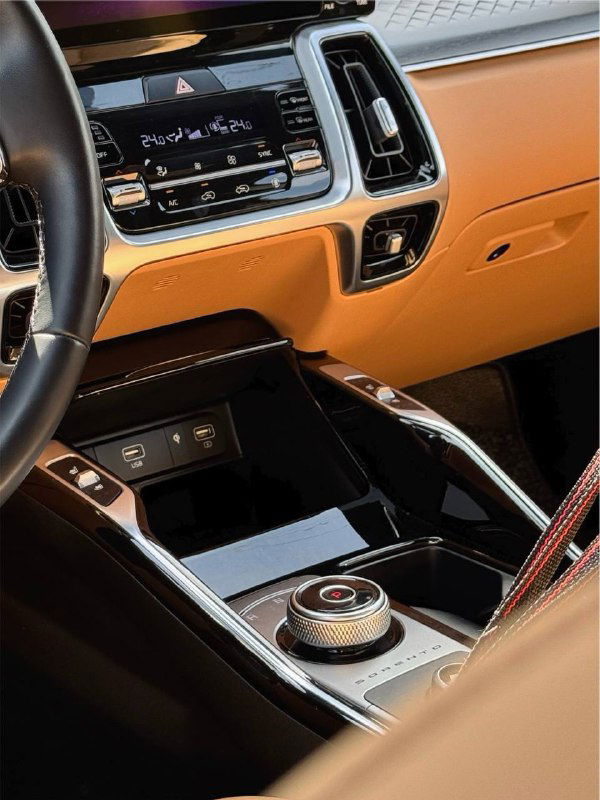 Центральная консоль и панель управления KIA Sorento 2020: сенсорный дисплей, климат-контроль и отделка в бежево-черной гамме, вид салона с переднего ряда.