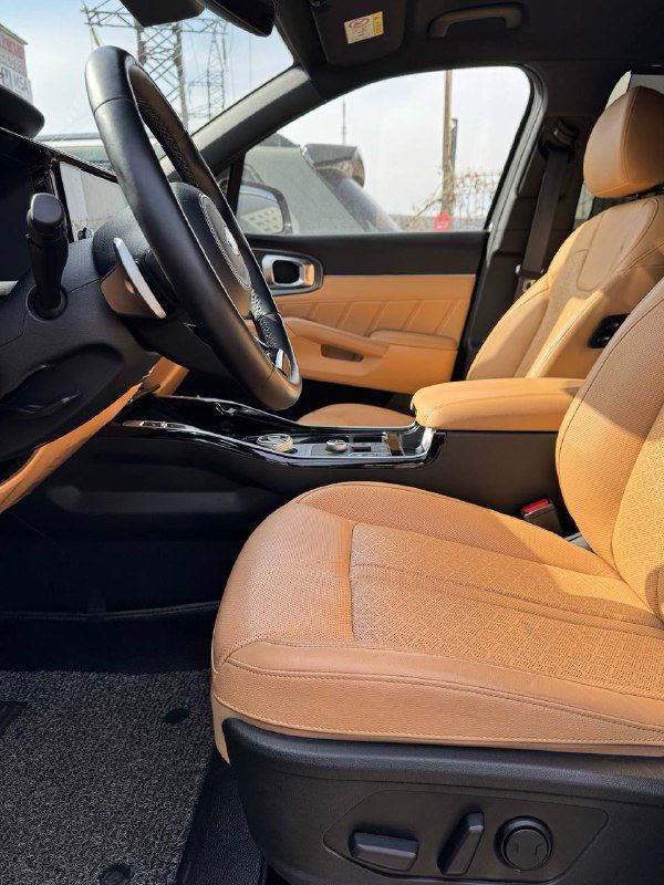 Передние кресла KIA Sorento 2020 в бежевой отделке: комфортные сиденья, центральный подлокотник и общий вид пассажирского пространства передним рядом.