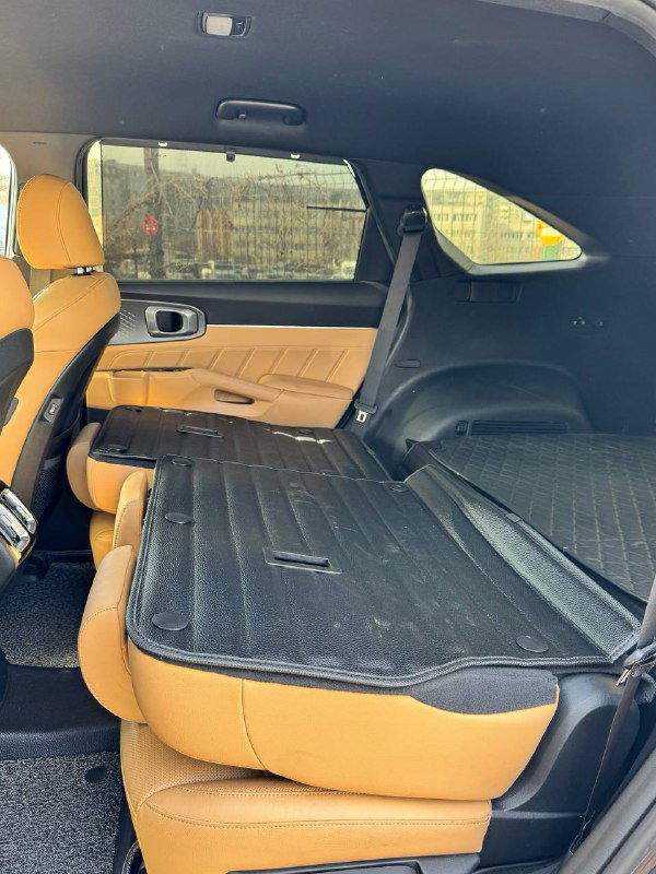 Сложенные задние сиденья KIA Sorento: вид грузового пространства с откинутыми сиденьями, показано пространство багажника и практичность конфигурации салона.