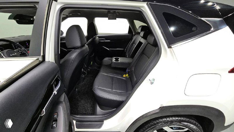 Задний ряд сидений KIA Seltos 2022 — фотография с открытой дверью, видны посадочные места, обивка и пространство для пассажиров на заднем ряду.