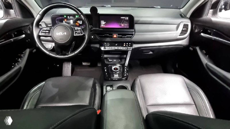 Интерьер KIA Seltos 2022 — вид сзади на переднюю панель и сиденья, отображающий состояние приборной панели и центрального туннеля.