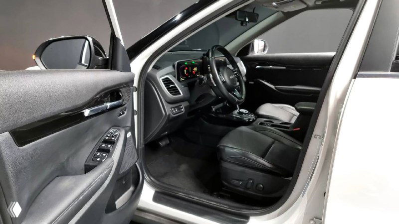 Открытая передняя дверь KIA Seltos 2022 — вид на салон со стороны пассажира, показывает переднюю панель и обивку сиденья крупным планом.