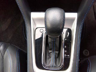 Крупный план селектора АКПП Subaru Levorg 2017 с чёрной кожаной ручкой и декоративной прострочкой, вид центральной консоли.