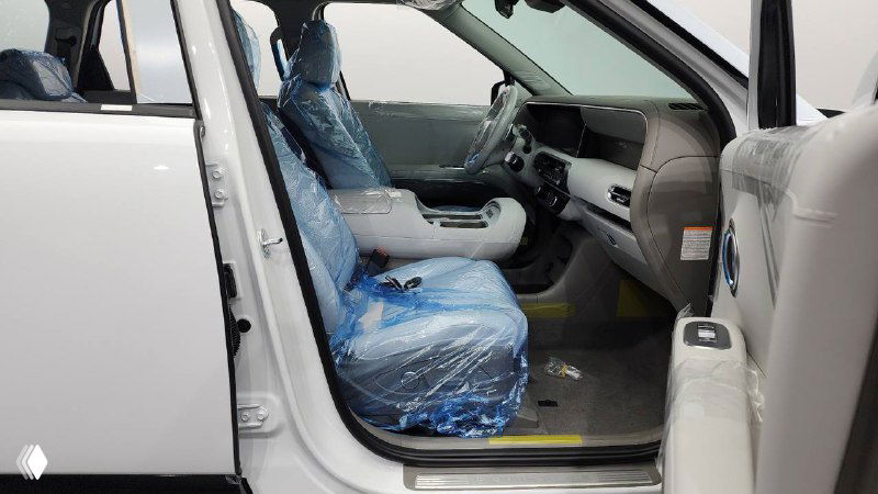 Открытая передняя дверь Hyundai Palisade 2025 и водительское кресло в защитной пленке, вид на порог и часть салона, новый пробег 20 км