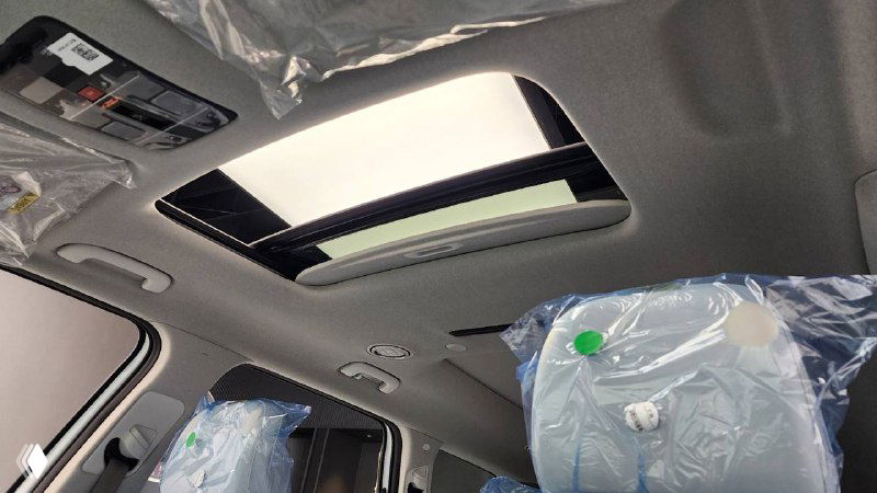 Люк на крыше и часть переднего пассажирского кресла Hyundai Palisade 2025, верхняя часть салона с защитными материалами и стеклянным люком