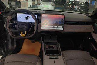 Интерьер и панель приборов Lynk & Co 08: рулевое колесо, большой центральный сенсорный экран и отделка торпеды в шоуруме.