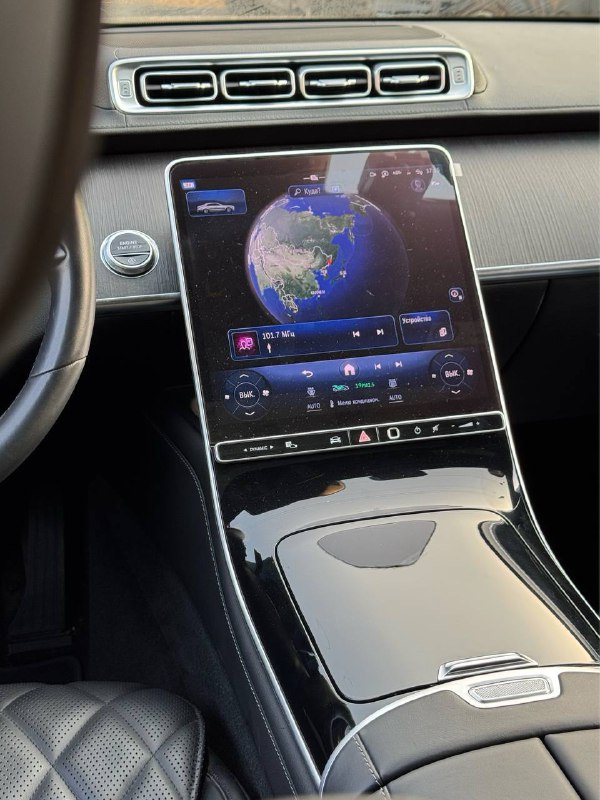 Центральная консоль Mercedes S 350d с большим вертикальным сенсорным экраном мультимедиа, глянцевая отделка и элементы управления климата.