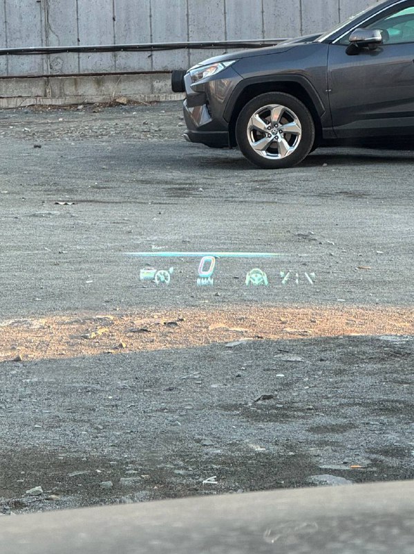 Проекция head-up display на лобовом стекле Mercedes S 350d: скорость и индикаторы видны на фоне асфальта городской парковки.