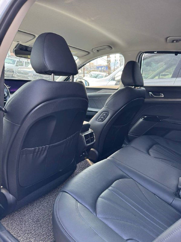 Салон KIA K5 — вид задних сидений и пространства для пассажиров, ракурс показывает отделку и подголовники.