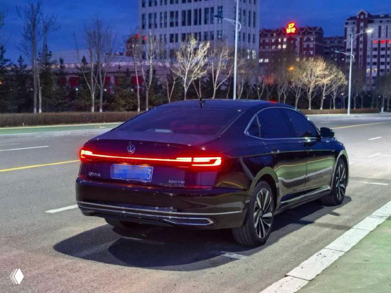 Задняя часть чёрного Volkswagen Passat 2022, ночная улица, задние фонари и профиль кузова, автомобиль в плёнке.