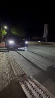 Ночное фото автомобиля, стоящего рядом с рампой погрузки; видна металлическая аппарель и дорожное покрытие, подготовка к загрузке.