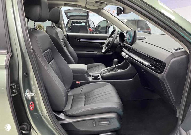 Интерьер Honda Breeze: передние сиденья, руль и мультимедийный экран на торпедо; видно центральную консоль и отделку салона вблизи.