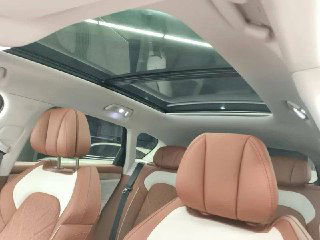 Панорамный люк и задние сиденья Voyah Free: крупный план потолка, светлый интерьер и коричневые кожаные подголовники на заднем ряду.