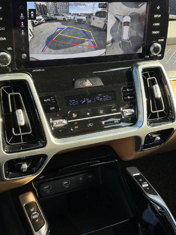 Экран мультимедийной системы KIA Sorento с изображением камеры заднего вида и обзором окружения — показывается функционал парковки.