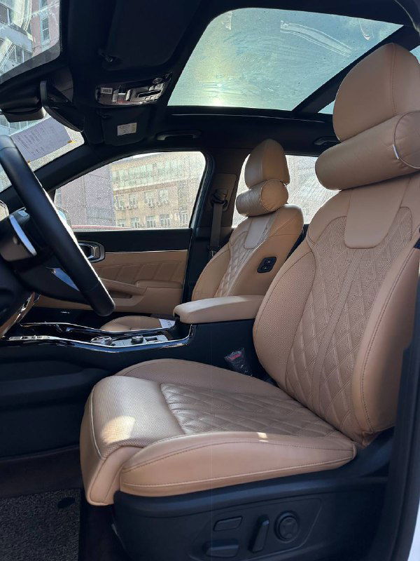 Передние сиденья KIA Sorento с панорамной крышей — вид под углом, показывающий пространство и отделку потолка.