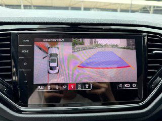 Экран мультимедиа Volkswagen T‑Roc показывает обзор с камер: отображение зоны парковки, траектории и габаритов автомобиля на дисплее центральной консоли.