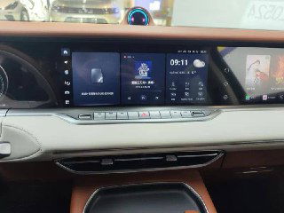 Широкий панорамный дисплей на торпеде Voyah Free, показаны мультимедиа-интерфейс, часы и элементы управления климатом в крупном плане.