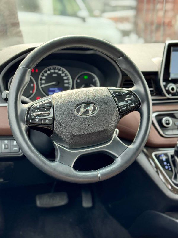 Рулевое колесо и панель приборов Hyundai Starex, крупный план руля с логотипом Hyundai и видимыми индикаторами на приборной панели.