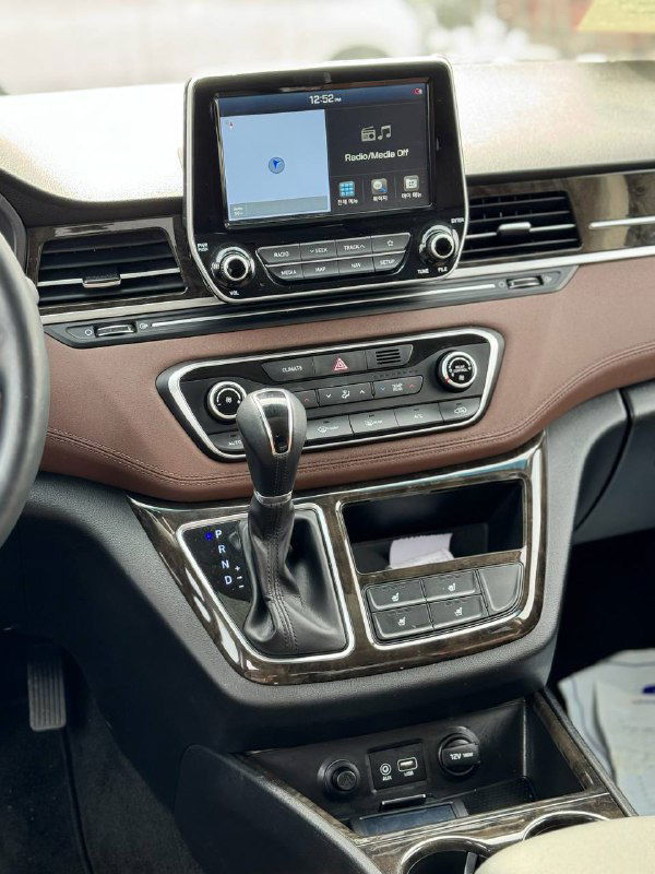 Центральная консоль и мультимедийный экран Hyundai Starex: селектор АКПП, кнопки управления климатом и экран навигации в салоне.