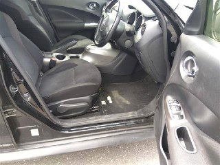 Открытая левая передняя дверь Nissan Juke 2012, виден салон и сиденье водителя — состояние обивки, порога и пола на момент осмотра на ярде.