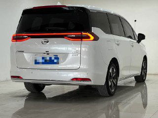 Задний ракурс белого GAC Trumpchi M6 в ангаре: светодиодная оптика, закрытая багажная дверь и отражения на блестящем полу фотозоны для продажи автомобиля.