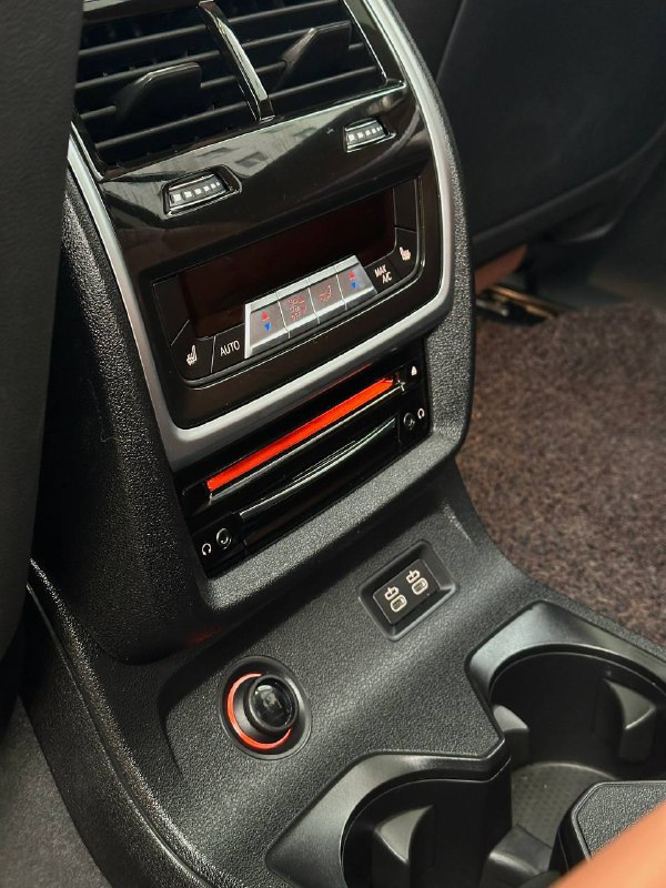 Задняя консоль между креслами BMW X7 с вентиляционными соплами и дополнительными элементами управления температурой для пассажиров.