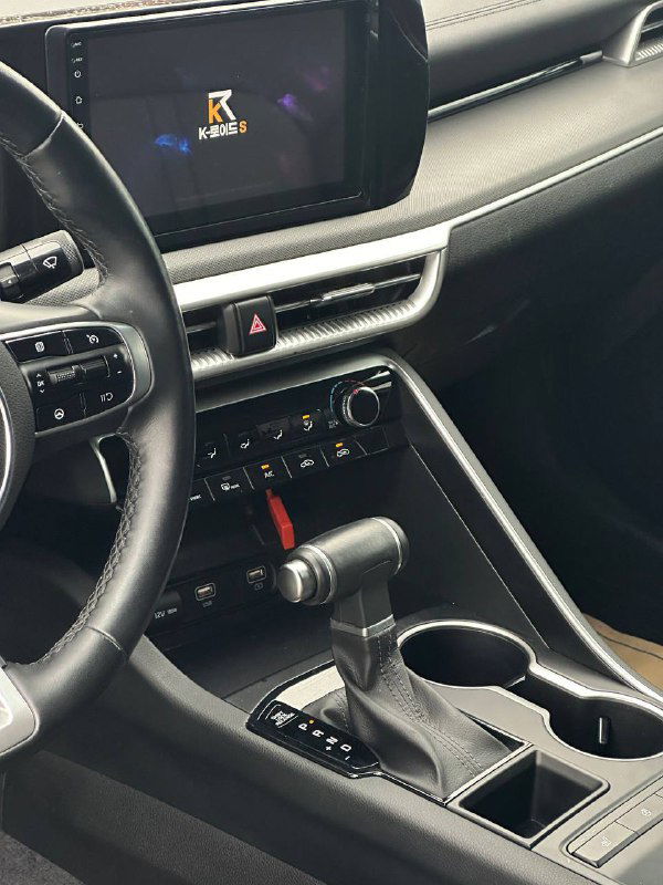 Мультимедийный экран и воздуховоды на центральной панели KIA K5, вид селектора передач и расположения элементов управления мультимедиа.