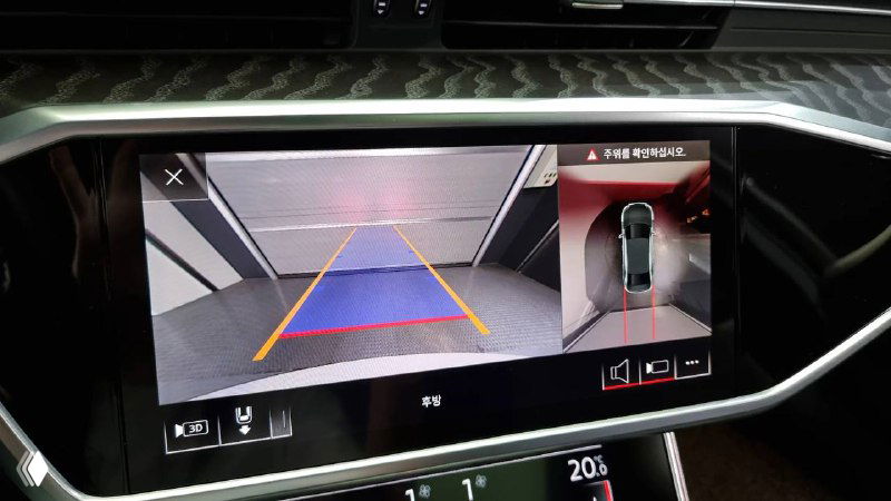 Крупный план экрана камеры заднего вида Audi A6: изображение парковочной разметки на дисплее мультимедийной системы, демонстрация работоспособности систем помощи при парковке